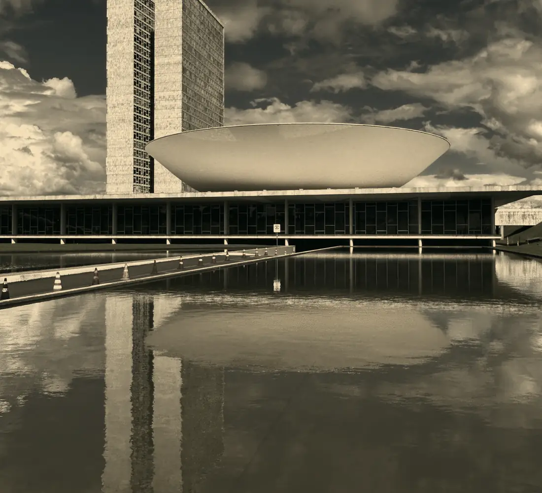 Edifício institucional de arquitetura moderna refletido em um espelho d'água