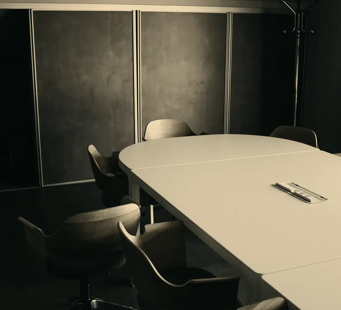 Sala de reuniões com mesa oval e cadeiras ao redor